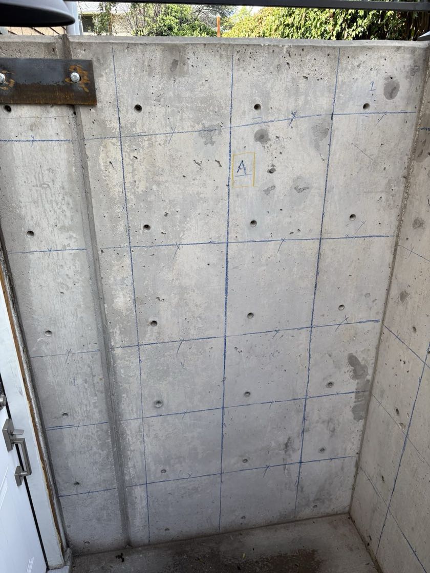 Cast concrete stairwell wall with a blue crayon grid of scan findings and the label A